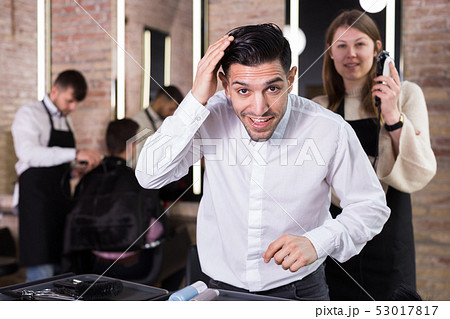 Satisfied man approving result of hairdresser work Satisfied man approving result of hairdresser work 53017817