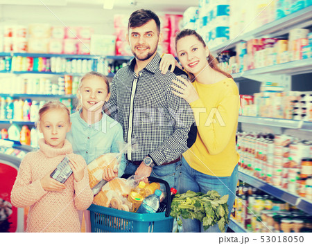 Young friendly family of four with full basket Young friendly family of four with full basket 53018050