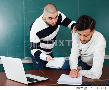 Students working with laptop near blackboard 53018771