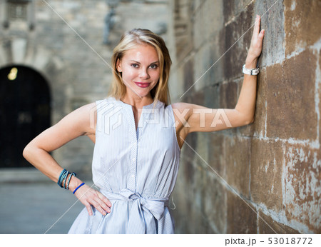 smiling woman near the stone wall 53018772