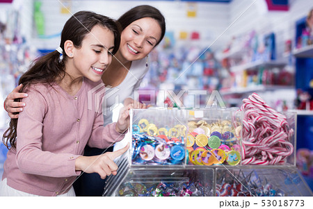 Woman with girl buying candies in the candy shop 53018773