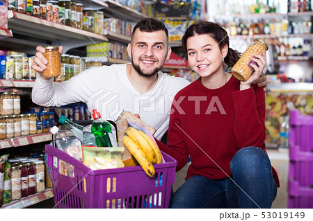vigorous young family choosing purchasing canned food for week at supermarket vigorous young family choosing purchasing canned food for week at supermarket 53019149