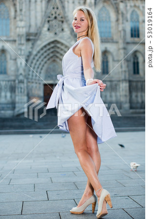 smiling woman holding dress in the hand 53019164
