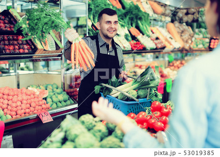 Male seller assisting in buying 53019385