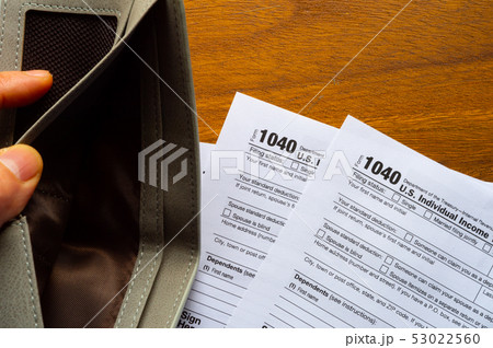 Tax day. The tax form 1040, and empty wallet is Tax day. The tax form 1040, and empty wallet is 53022560