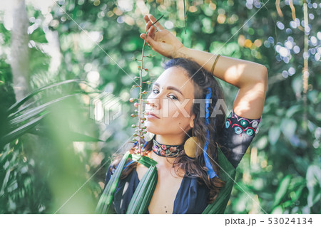 Young beautiful sensual brunette girl on a tropical garden background in ethnic Indian boho style, Young beautiful sensual brunette girl on a tropical garden background in ethnic Indian boho style, 53024134