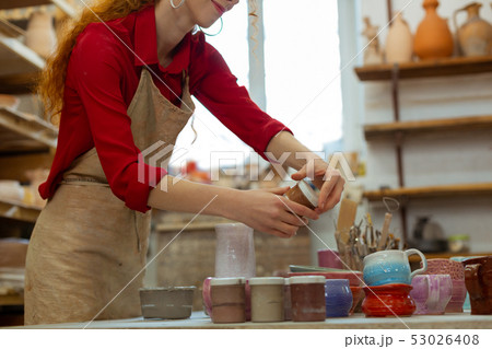 Pleasant long-haired girl in red shirt preparing paints Pleasant long-haired girl in red shirt preparing paints 53026408