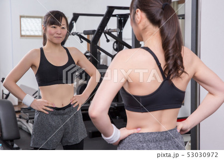 スポーツジムでボディラインをチェックする女性 53030972