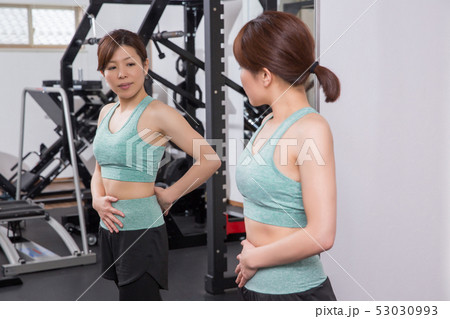 スポーツジムでボディラインをチェックする女性 53030993