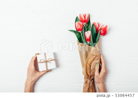 Female's hands holding small gift box Female's hands holding small gift box 53064457
