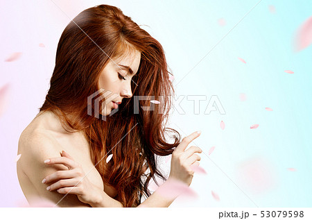 Redheaded woman over fresh blue background with swirl petals. Redheaded woman over fresh blue background with swirl petals. 53079598