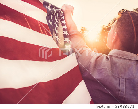 Handsome, young man waving an American flag Handsome, young man waving an American flag 53083671