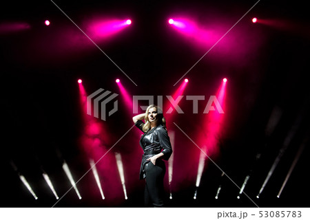 Young woman singer with colorful lights on concert 53085783