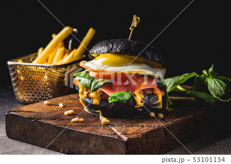 Hamburgers and French fries on the wooden tray. Hamburgers and French fries on the wooden tray. 53101134