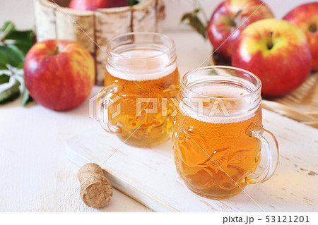 Two cups of Apple Cider and red apples 53121201