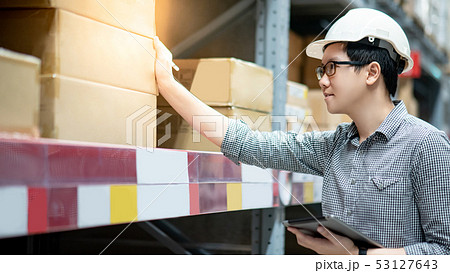 Asian man doing stocktaking on tablet in warehouse 53127643