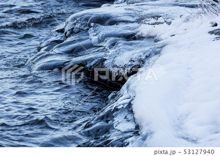 Ice frozen over rocks in lake shore Ice frozen over rocks in lake shore 53127940