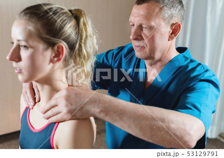 Male manual visceral therapist masseur treats a young female patient. Warm up the shoulders and neck Male manual visceral therapist masseur treats a young female patient. Warm up the shoulders and neck 53129791