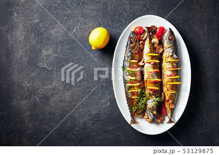 three broiled mackerels on an oval dish 53129875