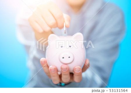 Photo of man throwing coin into piggy bank Photo of man throwing coin into piggy bank 53131564