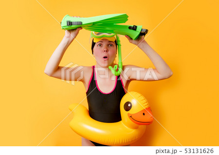 Image of woman with flippers in hands, swimming mask and with life preserver on empty orange 53131626