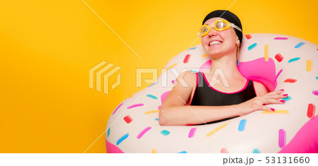 Image of happy girl in swimming goggles, swimsuit with donut life buoy on empty orange background Image of happy girl in swimming goggles, swimsuit with donut life buoy on empty orange background 53131660