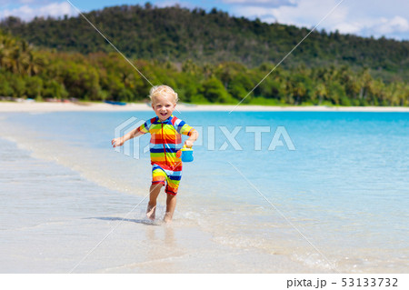 Kids play on tropical beach. Sand and water toy. 53133732