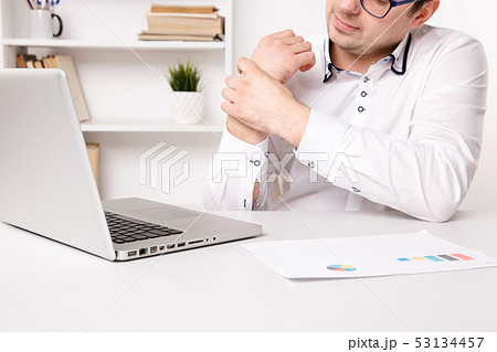 Illness hands of young businessman. Tired working on a laptop. 53134457