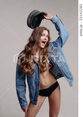 Model in underwear, denim jacket and kepi laughing Model in underwear, denim jacket and kepi laughing 53142283
