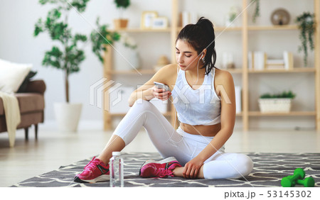 girl doing sports fitness at home resting and girl doing sports fitness at home resting and 53145302