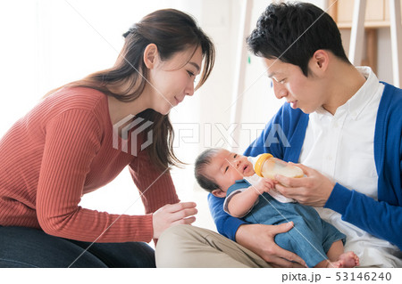 赤ちゃんに哺乳瓶でミルクを飲ませる若い夫婦 子育て 育児 53146240