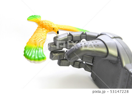 A little bird is sitting on the finger of a robot. 53147228