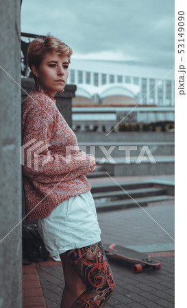 Beautiful young girl with tattoos with longboard 53149090
