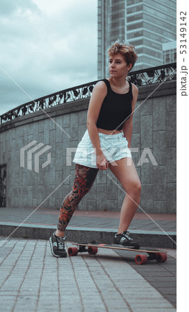 Beautiful young girl with tattoos with longboard 53149142