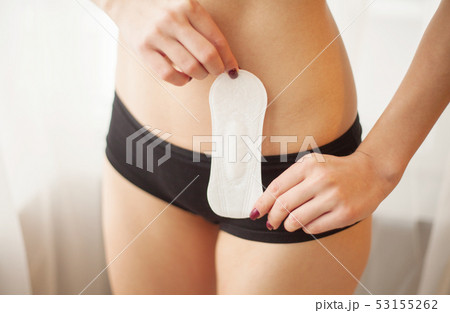 Female Hygiene. Closeup Of Beautiful Woman With Fit Slim Body In White Underwear Holding Sanitary 53155262