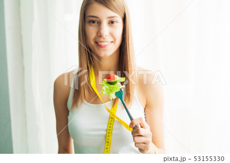 Diet. Portrait of a happy playful girl eating fresh salad 53155330