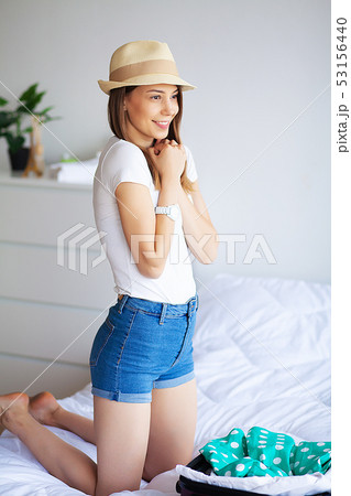 Woman legs raised up on the baggage, Young woman at home laying in bed. The white bedroom 53156440