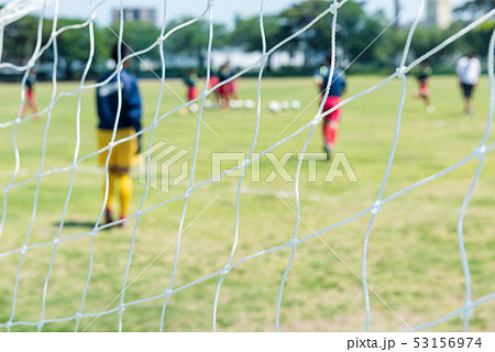 ネット越しのサッカーの風景の写真素材
