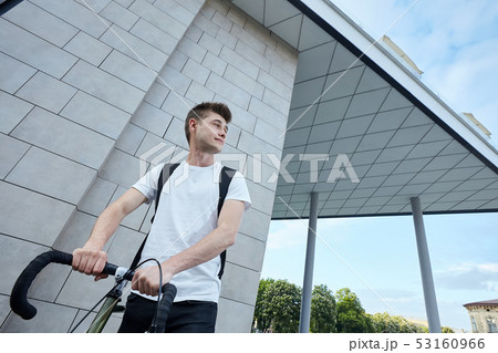 Handsome hipster man posing with bicycle in the city. 53160966
