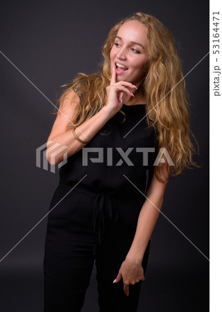 Young beautiful businesswoman with long wavy blond hair against  53164471