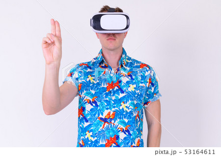 Portrait of young tourist man touching air while using virtual reality headset Portrait of young tourist man touching air while using virtual reality headset 53164611