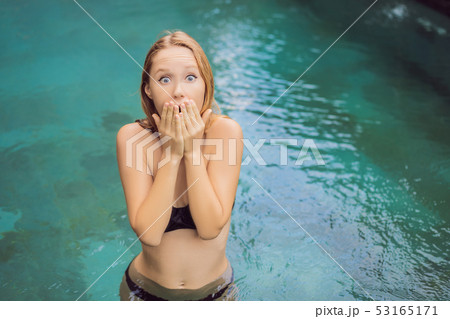 Frustrated young woman having a bad skin in the pool. Due to the fact that chemicals in the pool 53165171