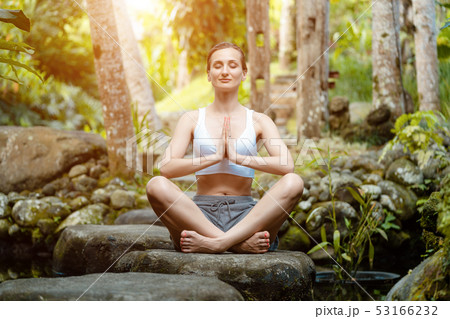 Woman doing yoga in the tropical jungle 53166232