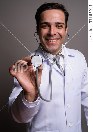 Handsome Persian man doctor against gray background 53167015