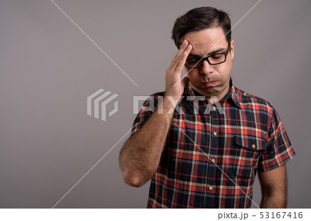 Handsome Persian man wearing eyeglasses against gray background Handsome Persian man wearing eyeglasses against gray background 53167416