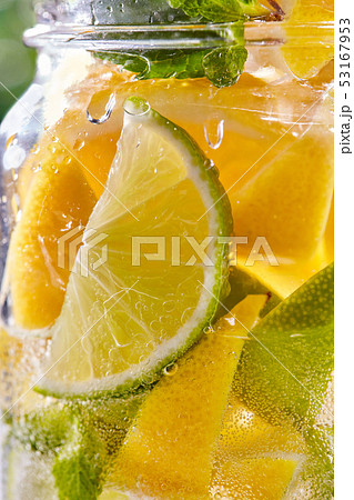 Cold refreshing water with lime and lemon in a glass. 53167953