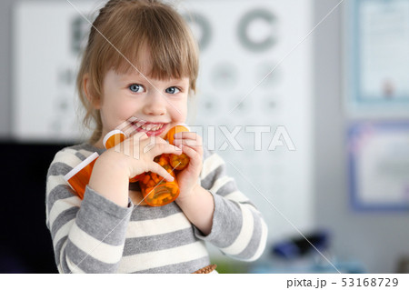 Cute smiling happy little girl grab pile of bottles with tablets Cute smiling happy little girl grab pile of bottles with tablets 53168729