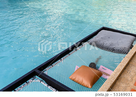 Mesh seat with pillows jut out on swimming pool 53169031