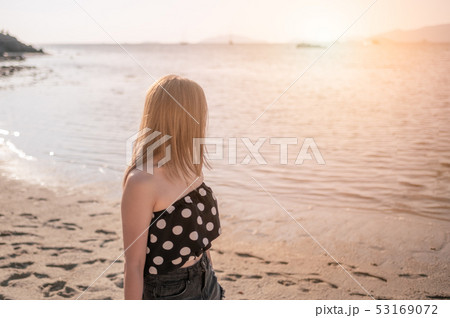 Young women swimwear walking on the beach 53169072