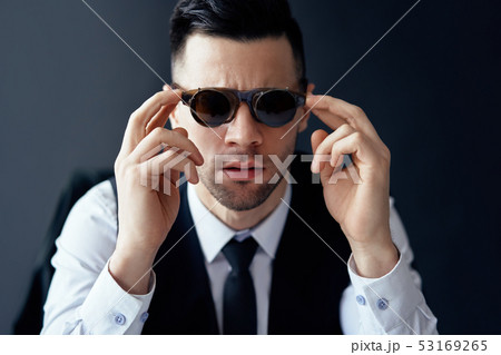 Handsome elegant man in retro sunglasses posing in studio 53169265